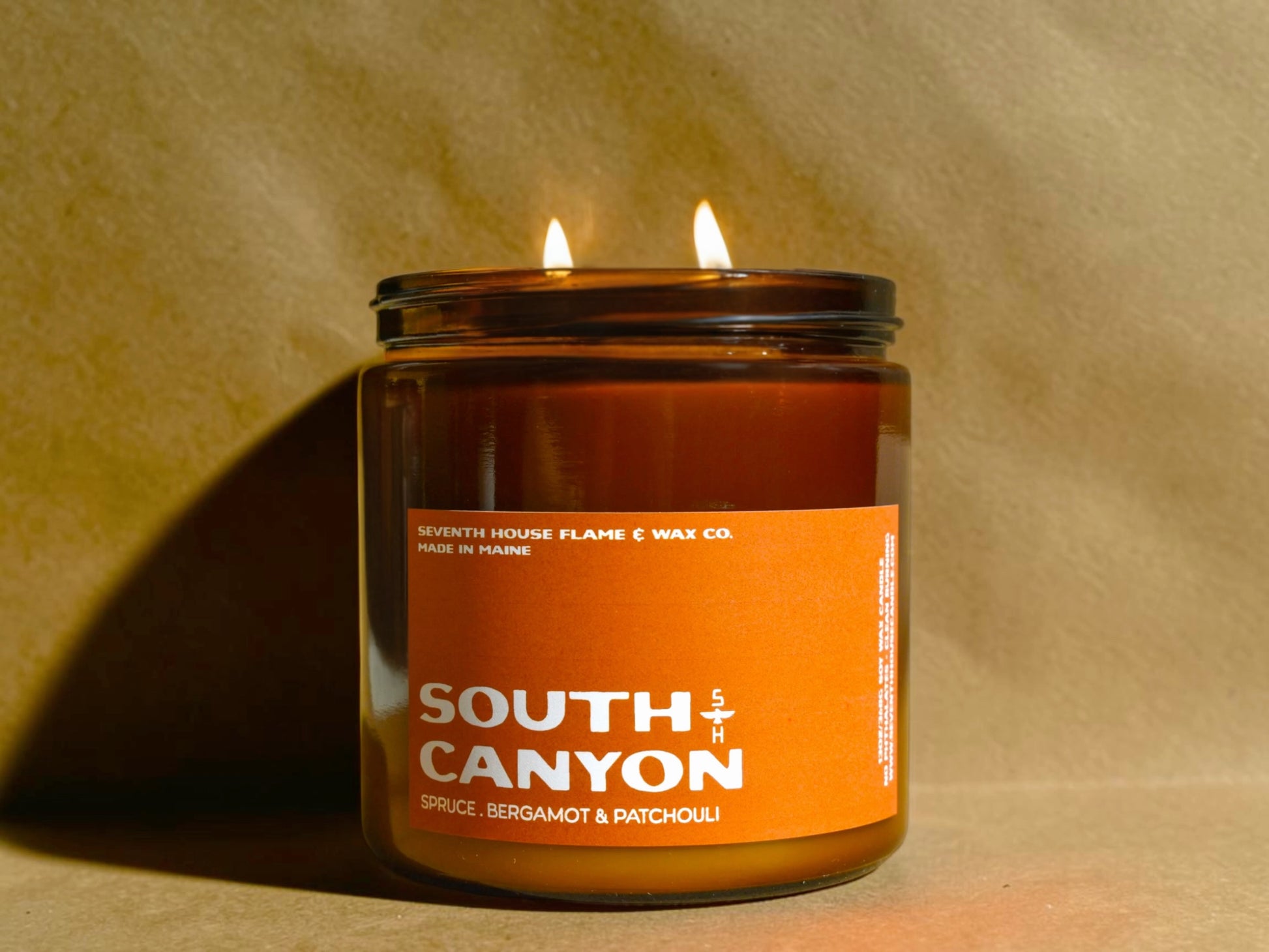 Candle in a jar labeled 'South Canyon' with an orange label on a beige background