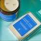 Candle with a wax melt next to it with the label reading, Cloud Nine".