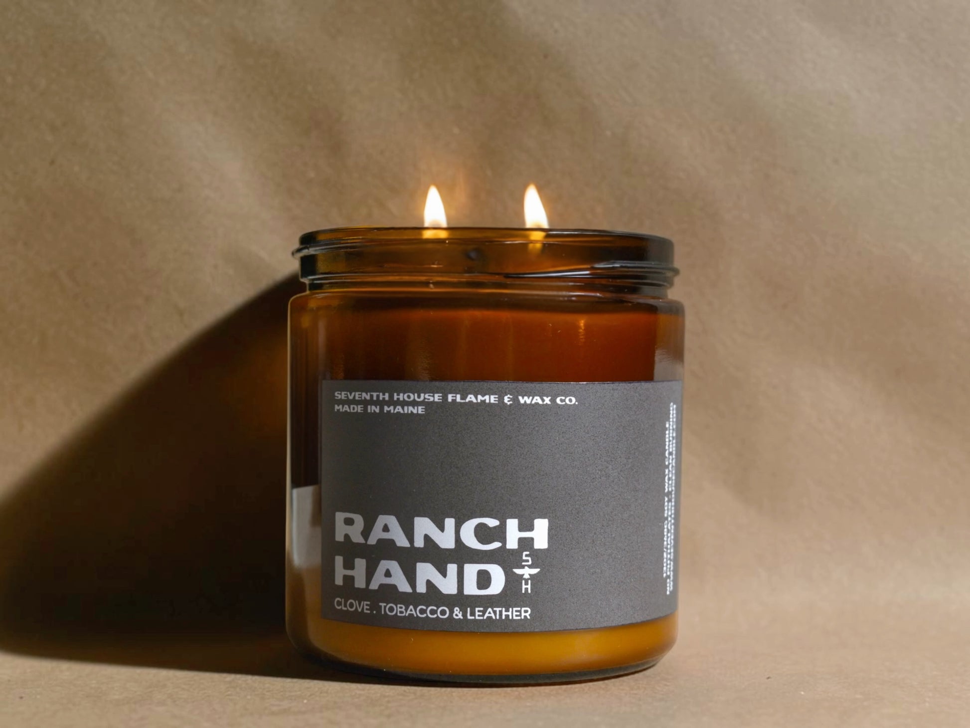 Candle in a glass jar labeled 'Ranch Hand' on a beige background