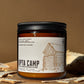 Candle jar with 'Upta Camp' label on a brown background