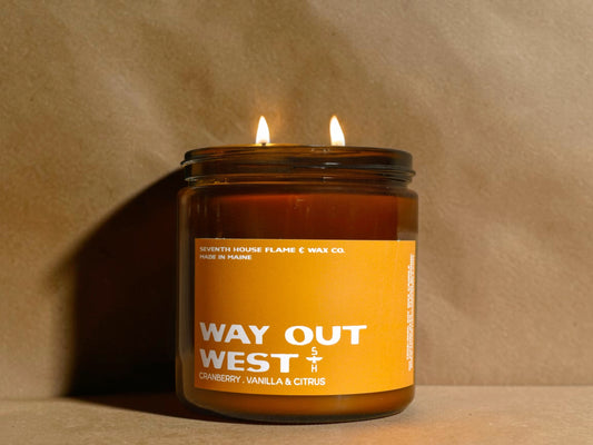 Candle in a glass jar with an orange label on a beige background
